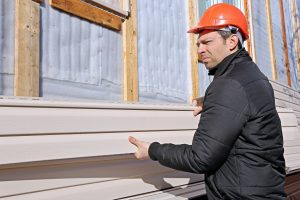 A man installs home siding materials